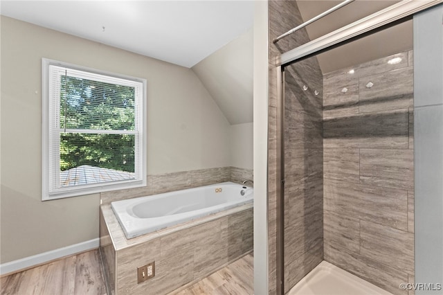 bathroom with hardwood / wood-style flooring, lofted ceiling, and plus walk in shower