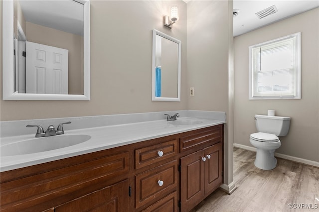 bathroom featuring wood-type flooring, vanity, and toilet