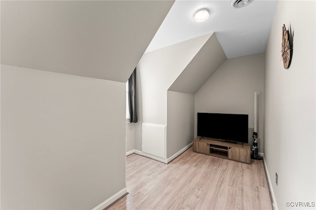 additional living space with lofted ceiling and light hardwood / wood-style floors