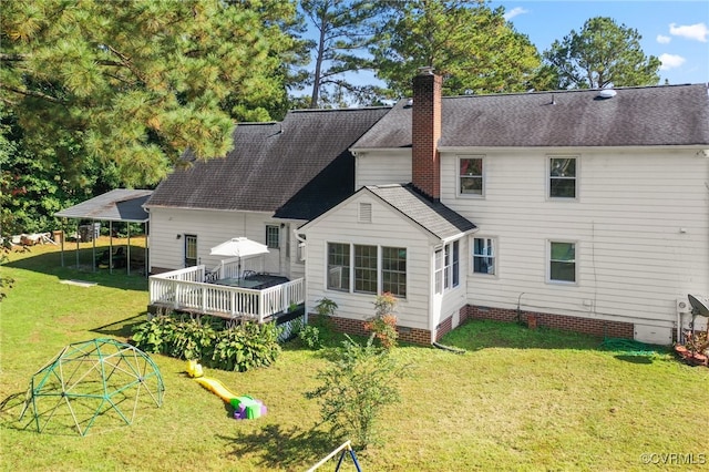 rear view of property featuring a wooden deck and a lawn