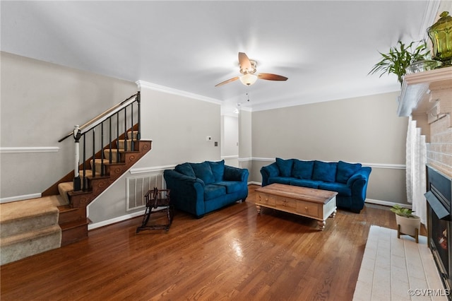 living room featuring crown molding, ceiling fan, and wood-type flooring