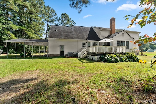 rear view of property with cooling unit, a carport, a lawn, and a wooden deck