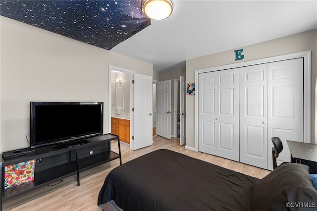 bedroom featuring light wood-type flooring, a closet, and connected bathroom