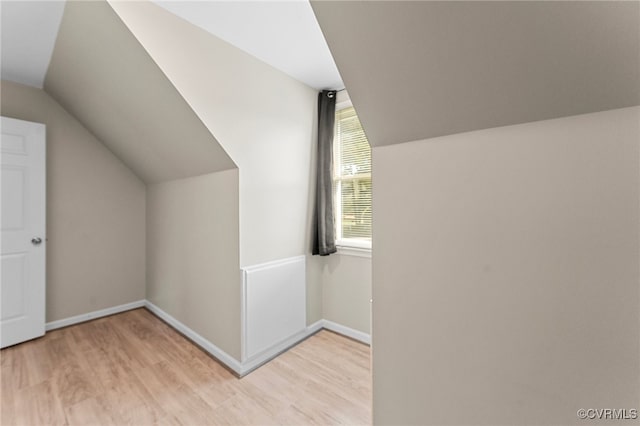 additional living space featuring lofted ceiling and light hardwood / wood-style floors