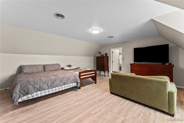 bedroom with vaulted ceiling and light wood-type flooring