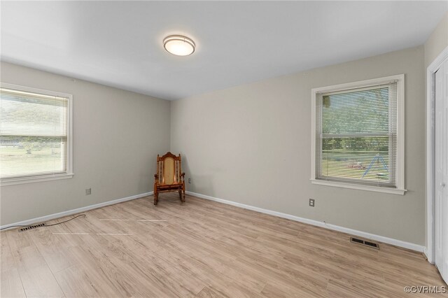 unfurnished room with plenty of natural light and light hardwood / wood-style flooring