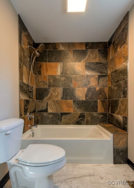 bathroom featuring toilet and tiled shower / bath