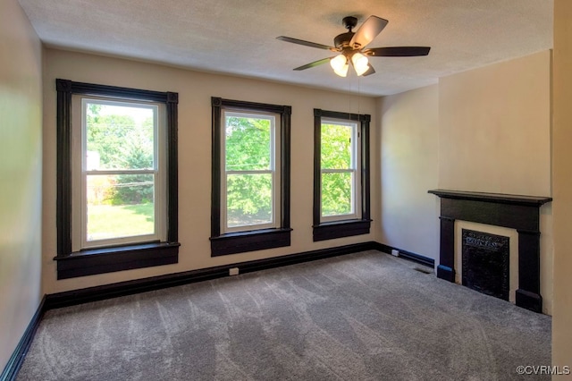 unfurnished living room featuring a textured ceiling, carpet, and ceiling fan