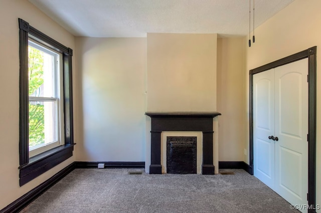 unfurnished living room with carpet and a textured ceiling