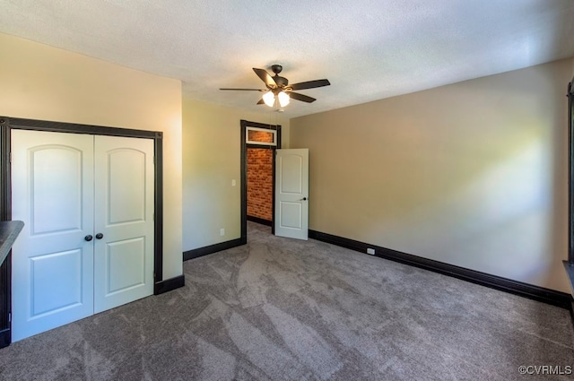 unfurnished bedroom featuring a textured ceiling, a closet, ceiling fan, and dark carpet