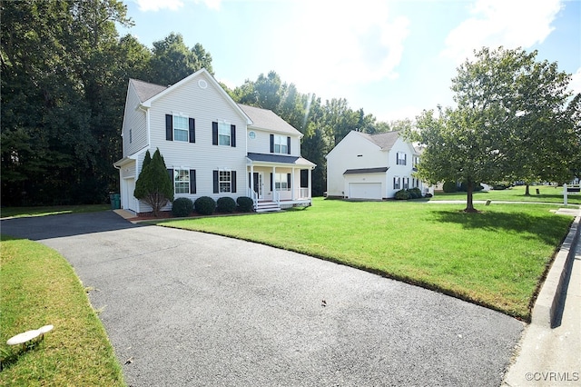 colonial inspired home with a porch, a front yard, and a garage