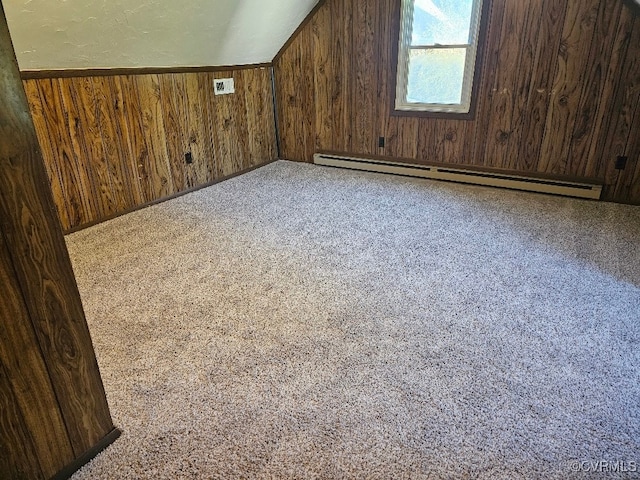 bonus room with a baseboard heating unit and wood walls