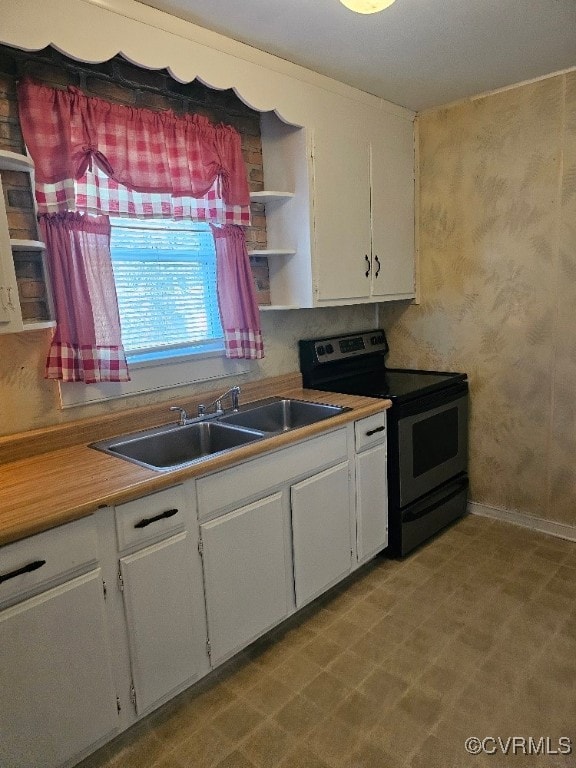 kitchen featuring white cabinetry, black range with electric cooktop, and sink