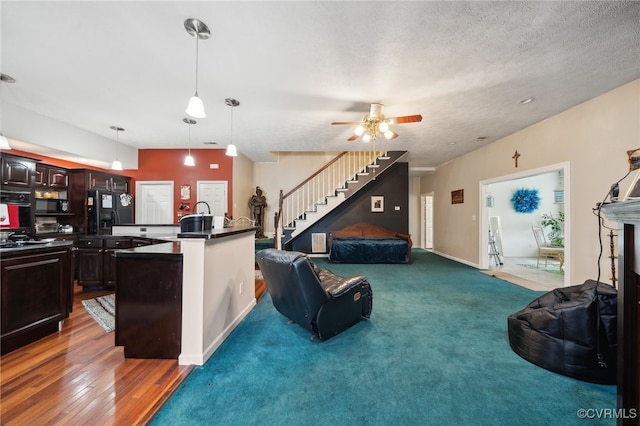 living room with ceiling fan, a textured ceiling, and dark hardwood / wood-style floors