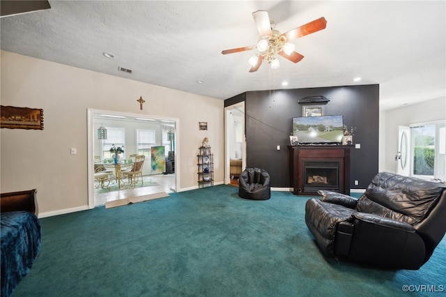 living room featuring ceiling fan, a textured ceiling, and carpet