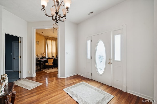 foyer featuring hardwood / wood-style flooring and a chandelier