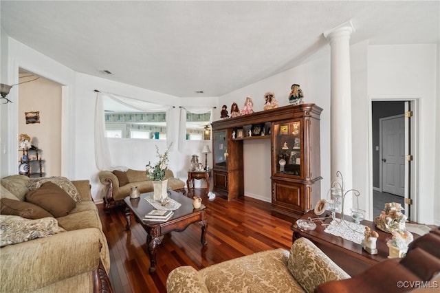 living room with decorative columns and dark hardwood / wood-style flooring