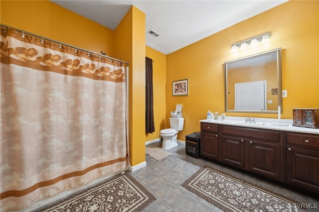 bathroom with walk in shower, vanity, tile patterned flooring, and toilet