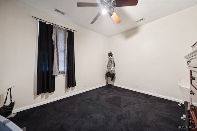 spare room featuring dark carpet and ceiling fan