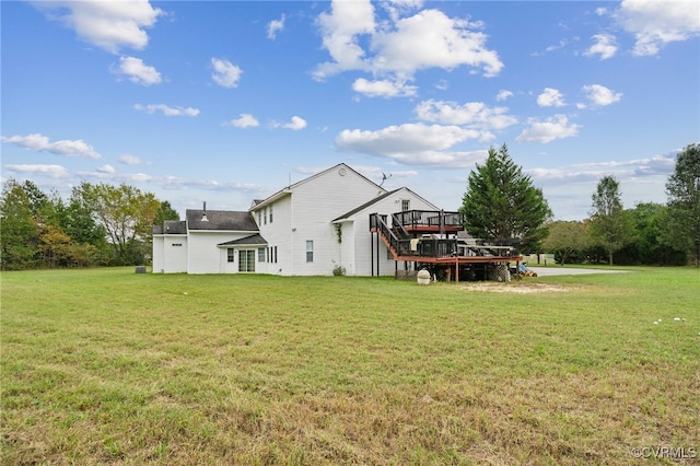 back of property with a wooden deck and a lawn