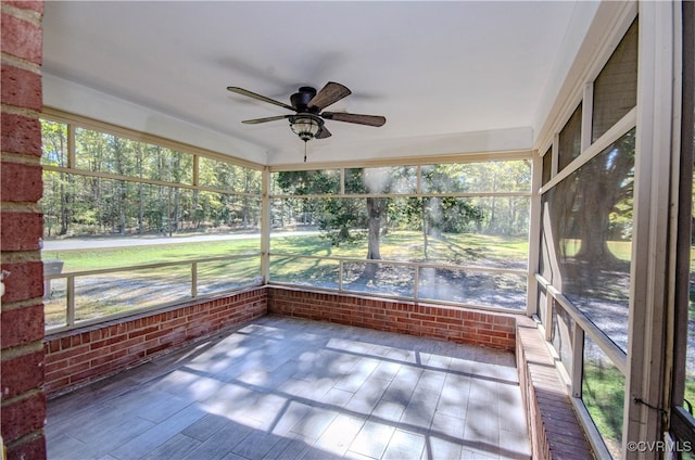 unfurnished sunroom featuring a healthy amount of sunlight and ceiling fan