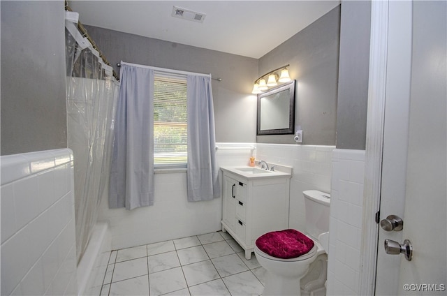 full bathroom featuring tile walls, vanity, plus walk in shower, and toilet