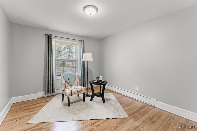 living area with hardwood / wood-style flooring and a baseboard radiator