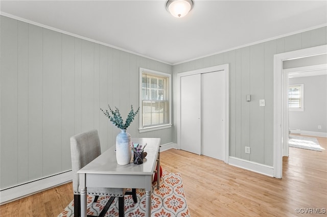 home office featuring ornamental molding, light hardwood / wood-style floors, and wood walls