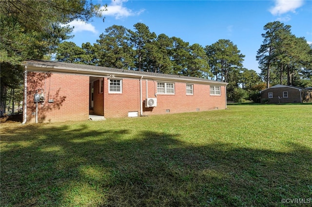 rear view of house featuring ac unit and a lawn