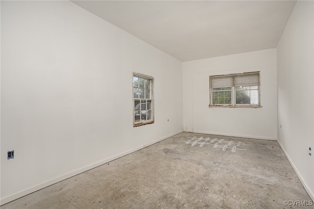 unfurnished room with concrete flooring