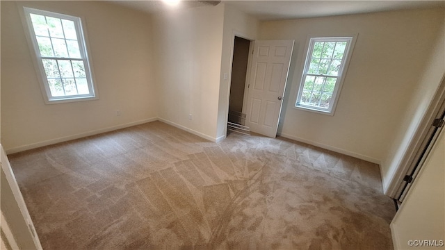 carpeted spare room featuring a healthy amount of sunlight