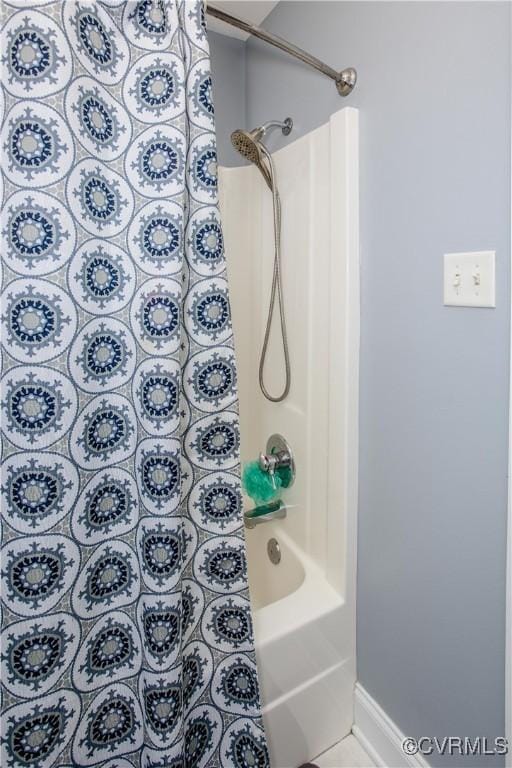 full bath featuring shower / bathtub combination and baseboards