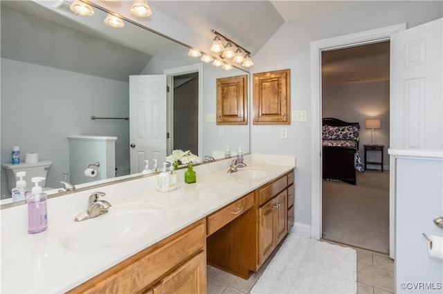 ensuite bathroom featuring lofted ceiling, a sink, toilet, and connected bathroom