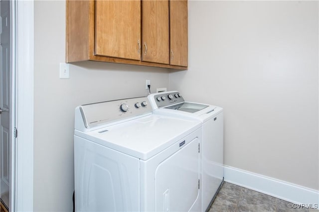 laundry room with washing machine and dryer, cabinet space, and baseboards