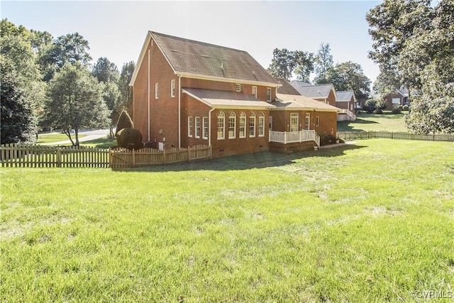 back of house with fence private yard, brick siding, and a lawn