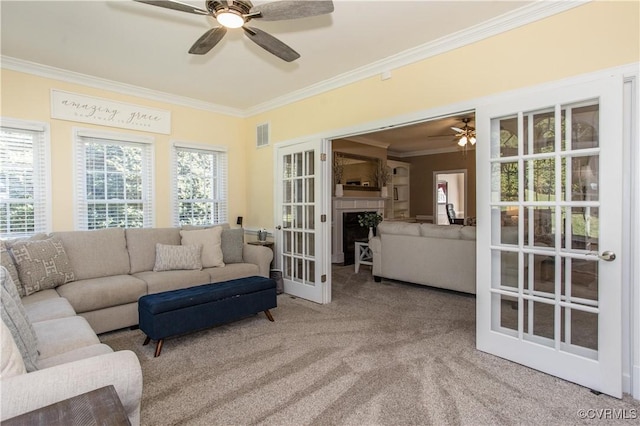 carpeted living room featuring ornamental molding, french doors, visible vents, and a fireplace