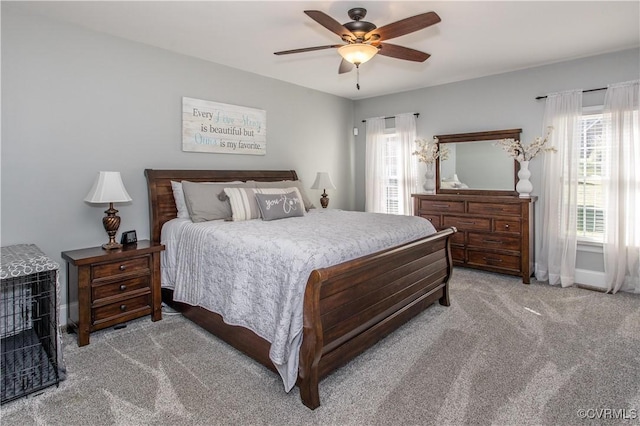 bedroom with light carpet, ceiling fan, and baseboards