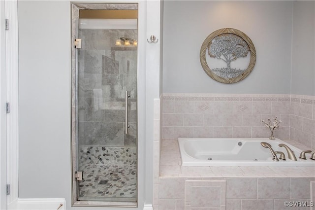 bathroom featuring a whirlpool tub and a shower stall