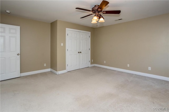 unfurnished bedroom featuring light colored carpet, a closet, visible vents, and baseboards