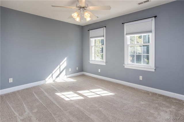 empty room with ceiling fan, carpet, visible vents, and baseboards