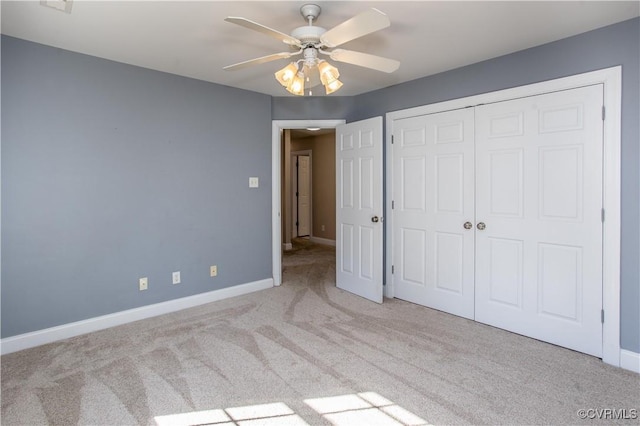 unfurnished bedroom featuring ceiling fan, a closet, carpet flooring, and baseboards