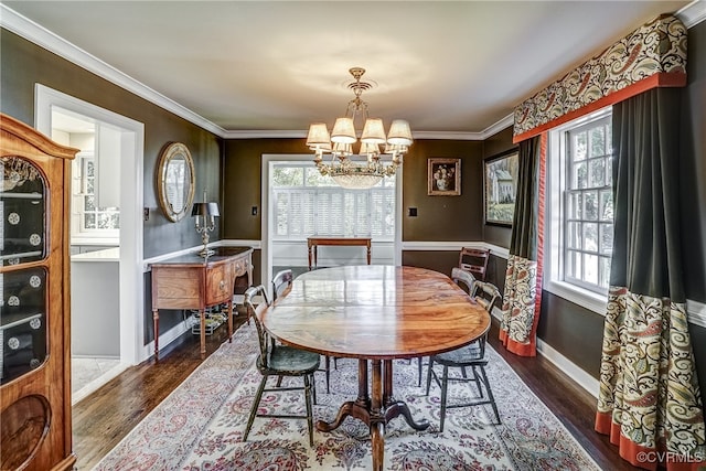 dining room with an inviting chandelier, ornamental molding, dark hardwood / wood-style floors, and a healthy amount of sunlight