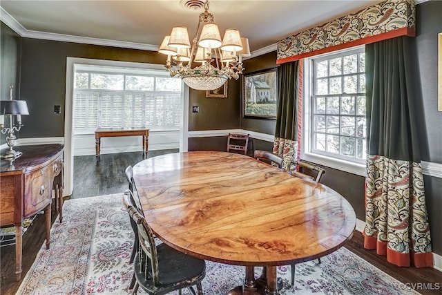 dining space featuring a notable chandelier, ornamental molding, and dark hardwood / wood-style flooring