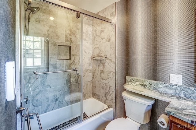 full bathroom with vanity, toilet, and combined bath / shower with glass door