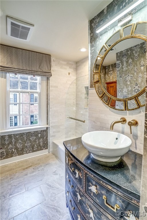 bathroom featuring vanity, shower with separate bathtub, and tile walls