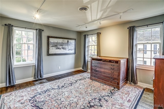 bedroom featuring rail lighting and wood-type flooring