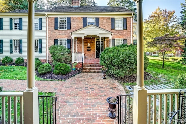 view of front of house with covered porch and a front yard