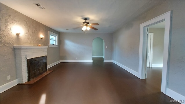 unfurnished living room with ceiling fan and a fireplace