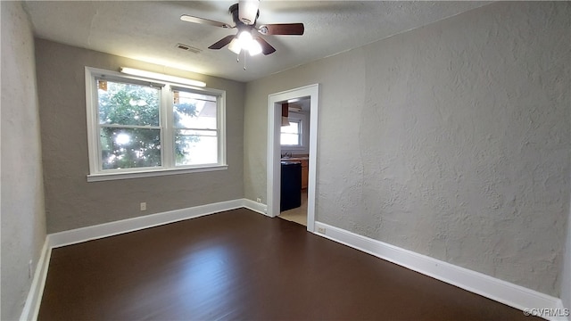 empty room featuring dark hardwood / wood-style floors, ceiling fan, and sink