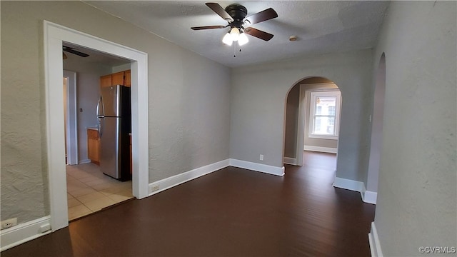 spare room featuring ceiling fan, wood-type flooring, and a textured ceiling